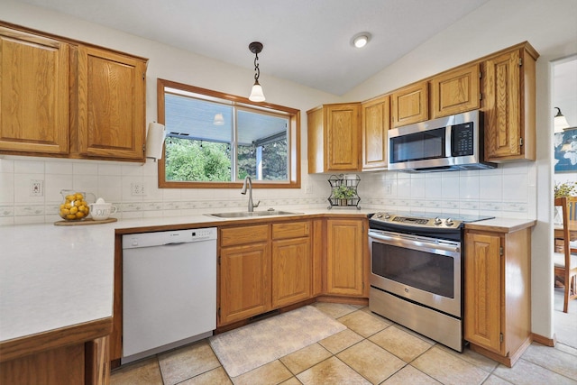 15618 N Chronicle Ct, Mead, WA 99021 - kitchen featuring appliances with stainless steel finishes, light countertops, brown cabinets, lofted ceiling, and tasteful backsplash