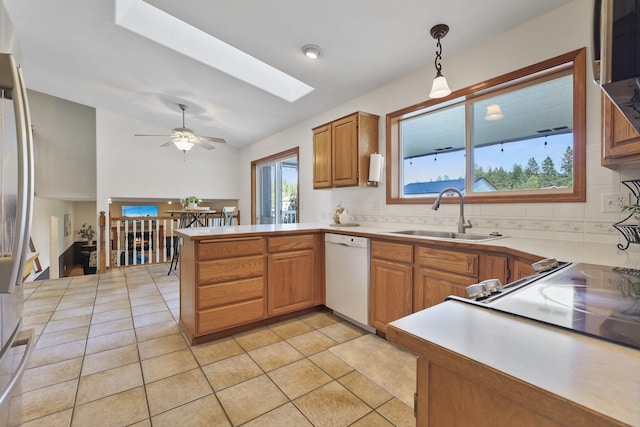 15618 N Chronicle Ct, Mead, WA 99021 - kitchen featuring dishwasher, a skylight, a peninsula, lofted ceiling, and backsplash