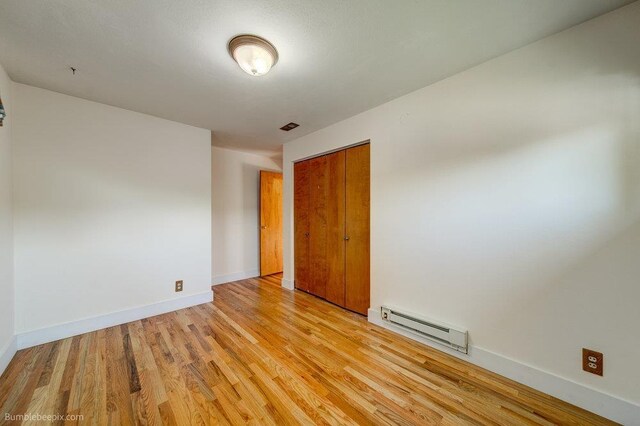 1003 W Eastmont Way, Spokane, WA 99208 - unfurnished room featuring a baseboard heating unit and light wood-style flooring