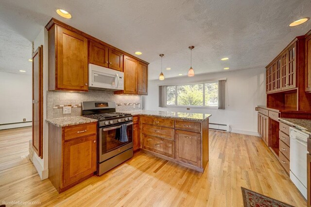 1003 W Eastmont Way, Spokane, WA 99208 - kitchen featuring white appliances, a peninsula, tasteful backsplash, brown cabinetry, and a baseboard heating unit