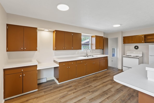 5804 N Maple St, Spokane, WA 99205 - kitchen with white appliances, light wood-type flooring, baseboard heating, light countertops, and brown cabinetry