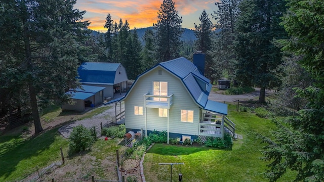 882 Diamond Creek Rd, Newport, WA 99156 - back of property at dusk with a gambrel roof, a lawn, stairway, a chimney, and a forest view