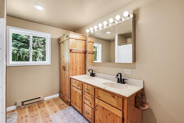882 Diamond Creek Rd, Newport, WA 99156 - bathroom featuring baseboard heating, plenty of natural light, double vanity, and wood finished floors