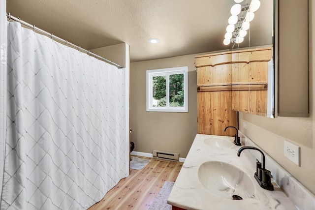 882 Diamond Creek Rd, Newport, WA 99156 - bathroom with hardwood / wood-style flooring, double vanity, a baseboard radiator, a shower with shower curtain, and a textured ceiling