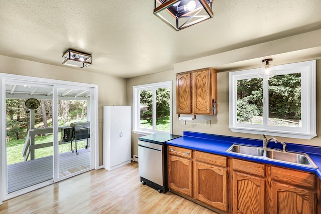 882 Diamond Creek Rd, Newport, WA 99156 - kitchen with fridge, brown cabinets, light wood-style floors, and a textured ceiling