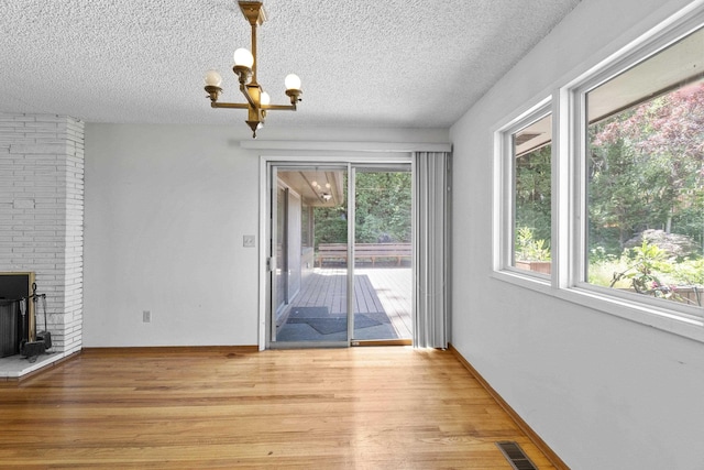 812 W Westover Rd, Spokane, WA 99218 - unfurnished dining area with a chandelier, light wood-type flooring, and a textured ceiling