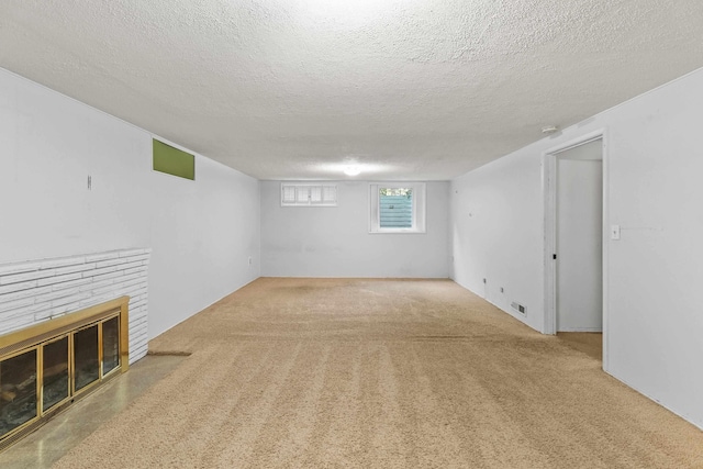 812 W Westover Rd, Spokane, WA 99218 - unfurnished living room featuring a textured ceiling, carpet, and a brick fireplace