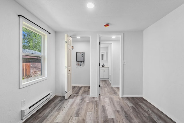 610 N 1st St, Springdale, WA 99173 - unfurnished room with a baseboard heating unit, wood finished floors, and recessed lighting