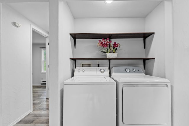 610 N 1st St, Springdale, WA 99173 - laundry room with separate washer and dryer, wood finished floors, and a baseboard heating unit