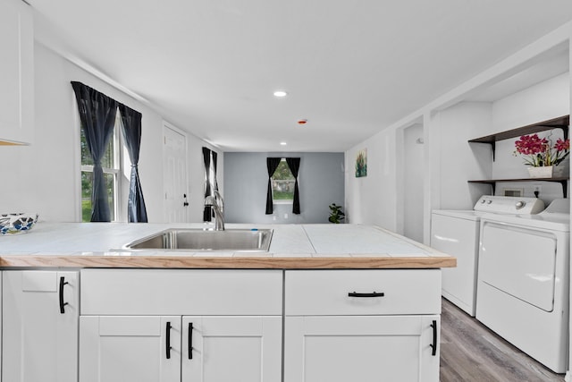 610 N 1st St, Springdale, WA 99173 - kitchen with washer and clothes dryer, light wood-style flooring, white cabinets, light countertops, and recessed lighting