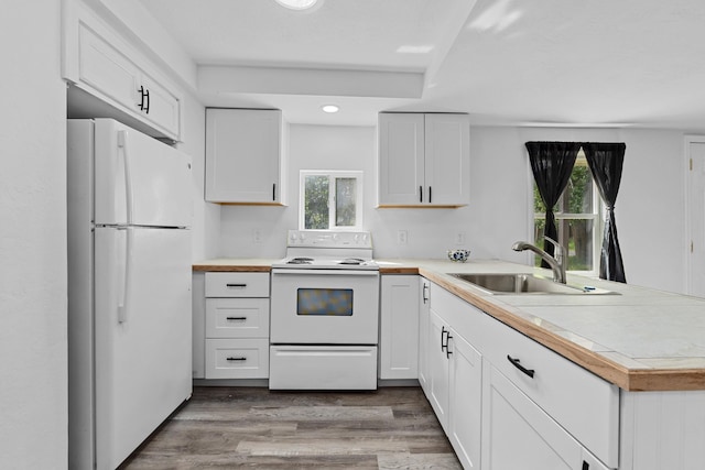 610 N 1st St, Springdale, WA 99173 - kitchen featuring white appliances, a peninsula, light countertops, white cabinets, and wood finished floors
