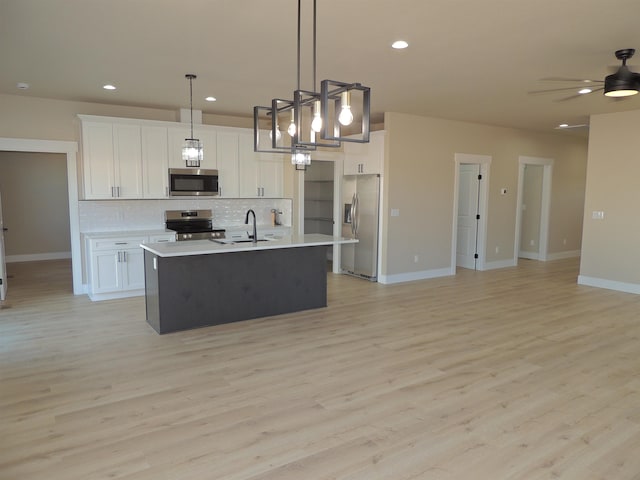 516 SW Alder St, Wilbur, WA 99185 - kitchen with appliances with stainless steel finishes, open floor plan, backsplash, light countertops, and white cabinets