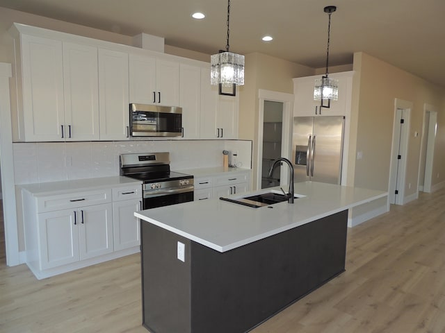516 SW Alder St, Wilbur, WA 99185 - kitchen with stainless steel appliances, a chandelier, light wood-style floors, a center island with sink, and recessed lighting