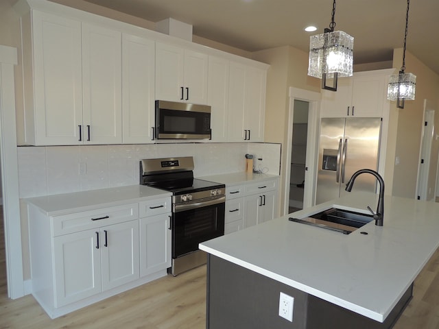 516 SW Alder St, Wilbur, WA 99185 - kitchen with appliances with stainless steel finishes, light wood finished floors, backsplash, recessed lighting, and hanging light fixtures