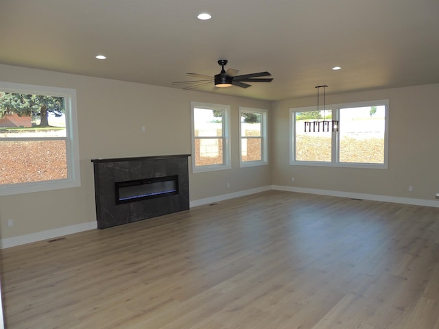 516 SW Alder St, Wilbur, WA 99185 - unfurnished living room featuring healthy amount of natural light, a high end fireplace, light wood finished floors, and recessed lighting