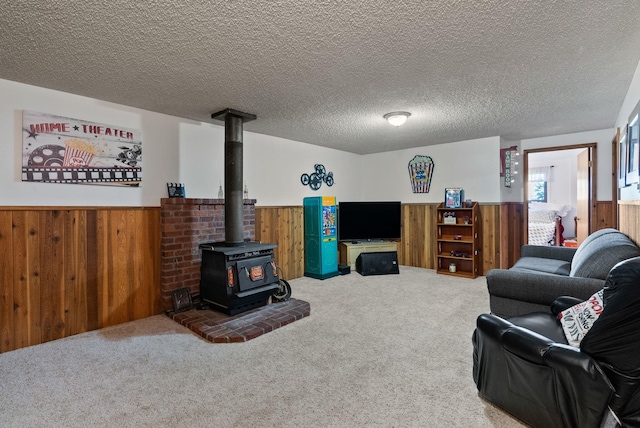 25210 E Bradshaw Rd, Fairfield, WA 99012 - living area featuring a wainscoted wall, wood walls, a wood stove, carpet flooring, and a textured ceiling