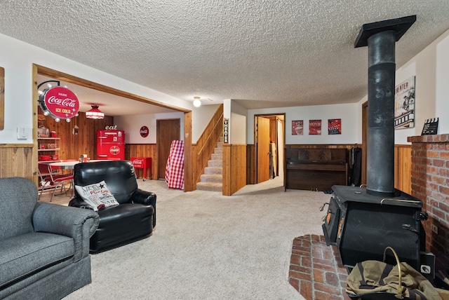 25210 E Bradshaw Rd, Fairfield, WA 99012 - carpeted living area with a wood stove, wooden walls, wainscoting, stairs, and a textured ceiling