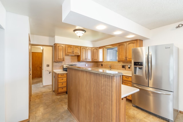 14006 E Cataldo Ave, Spokane Valley, WA 99216 - kitchen featuring stainless steel fridge with ice dispenser, light countertops, a center island, and tasteful backsplash