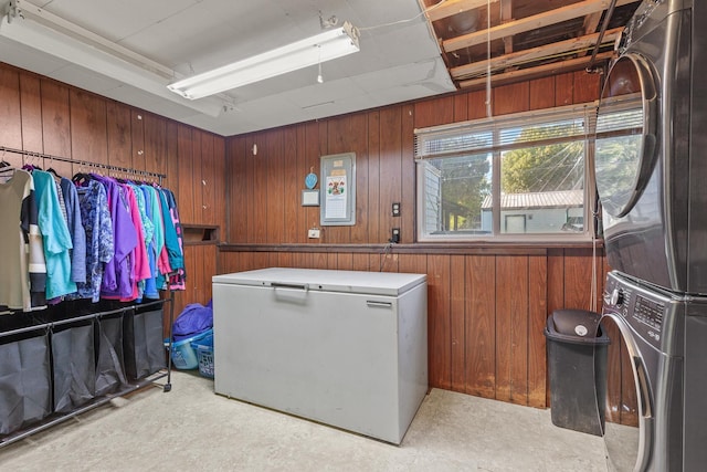 13015 E Mallon Ct, Spokane Valley, WA 99216 - washroom featuring stacked washer / dryer, wooden walls, and light flooring
