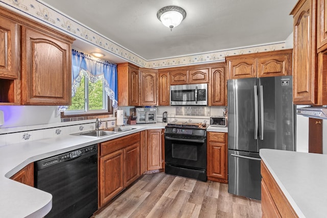 13015 E Mallon Ct, Spokane Valley, WA 99216 - kitchen featuring black appliances, light wood-style flooring, light countertops, and brown cabinets