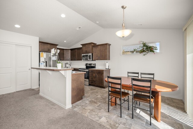 14520 E Everett Ct, Spokane Valley, WA 99216 - kitchen featuring appliances with stainless steel finishes, dark brown cabinets, lofted ceiling, light countertops, and pendant lighting