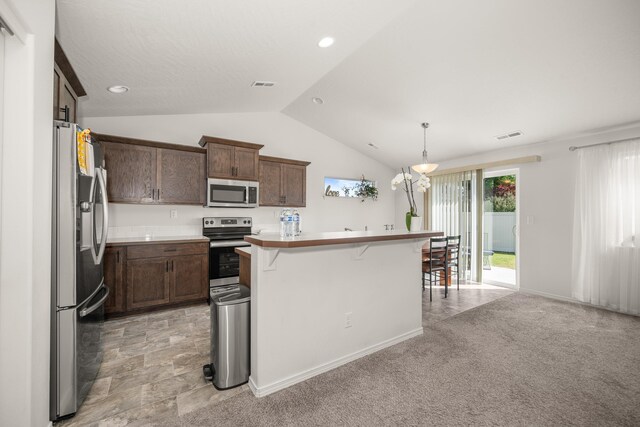 14520 E Everett Ct, Spokane Valley, WA 99216 - kitchen with stainless steel appliances, a breakfast bar, vaulted ceiling, light countertops, and decorative light fixtures