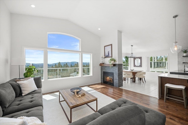 8422 E Sandlewood Ln, Spokane, WA 99217 - living area featuring wood finished floors, a glass covered fireplace, lofted ceiling, a chandelier, and recessed lighting