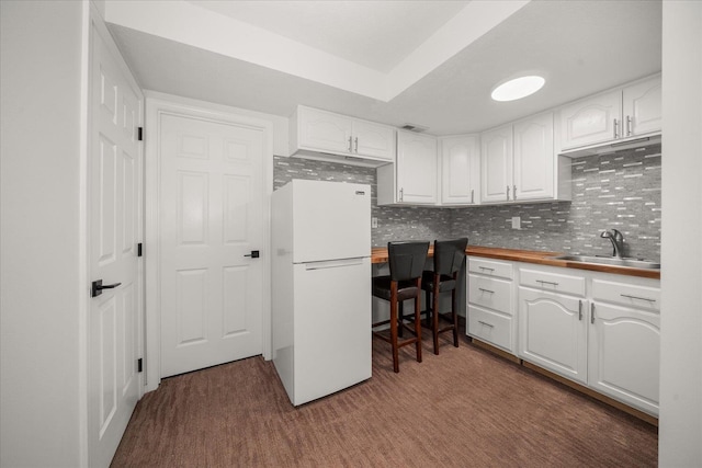8422 E Sandlewood Ln, Spokane, WA 99217 - kitchen with freestanding refrigerator, white cabinets, backsplash, and wooden counters