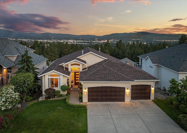 8422 E Sandlewood Ln, Spokane, WA 99217 - view of front of property with a garage, concrete driveway, a mountain view, a shingled roof, and a lawn