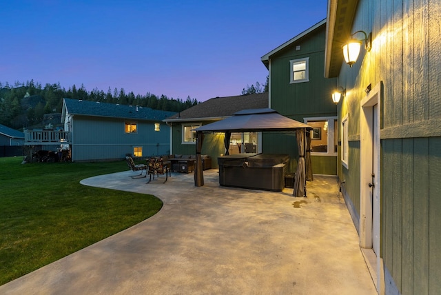 5981 Blackstone Way, Nine Mile Falls, WA 99026 - back of house at dusk with a hot tub, a patio area, a gazebo, and a yard