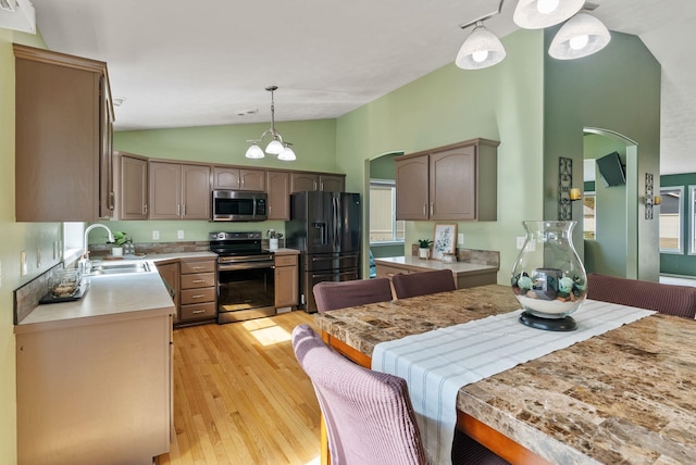 5981 Blackstone Way, Nine Mile Falls, WA 99026 - kitchen featuring stainless steel appliances, arched walkways, light wood-type flooring, light countertops, and pendant lighting