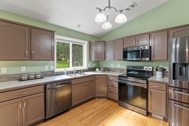 5981 Blackstone Way, Nine Mile Falls, WA 99026 - kitchen with stainless steel appliances, a chandelier, lofted ceiling, light wood-type flooring, and pendant lighting