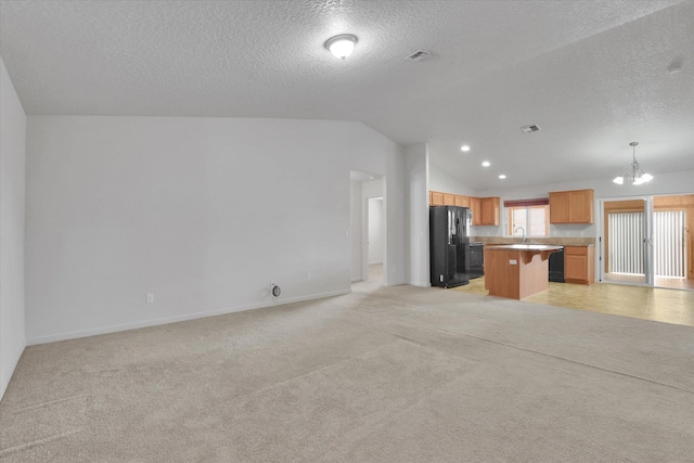 7316 S Dour St, Cheney, WA 99004 - unfurnished living room featuring light carpet, a chandelier, lofted ceiling, a textured ceiling, and recessed lighting