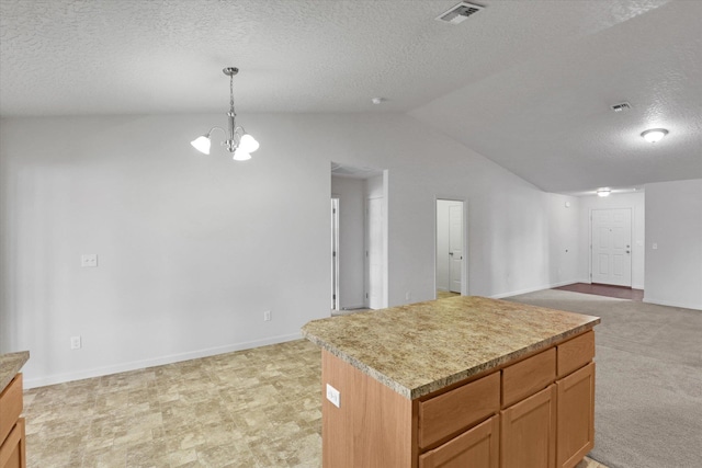 7316 S Dour St, Cheney, WA 99004 - kitchen with vaulted ceiling, a textured ceiling, a chandelier, a kitchen island, and pendant lighting