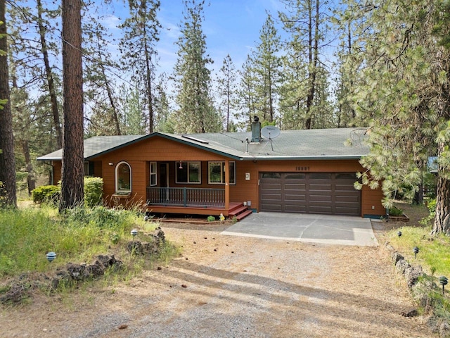 15007 W Willynwood Ln, Nine Mile Falls, WA 99026 - view of front facade featuring driveway, a garage, a chimney, and covered porch