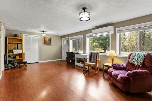 15007 W Willynwood Ln, Nine Mile Falls, WA 99026 - living area with a wall mounted air conditioner, a textured ceiling, and dark wood-style floors