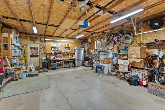 15007 W Willynwood Ln, Nine Mile Falls, WA 99026 - garage with a workshop area, freestanding refrigerator, and a garage door opener