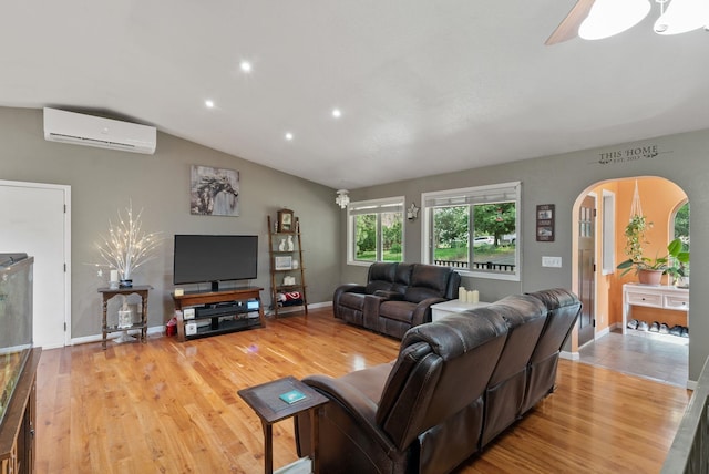 15007 W Willynwood Ln, Nine Mile Falls, WA 99026 - living area with an AC wall unit, arched walkways, wood finished floors, recessed lighting, and vaulted ceiling