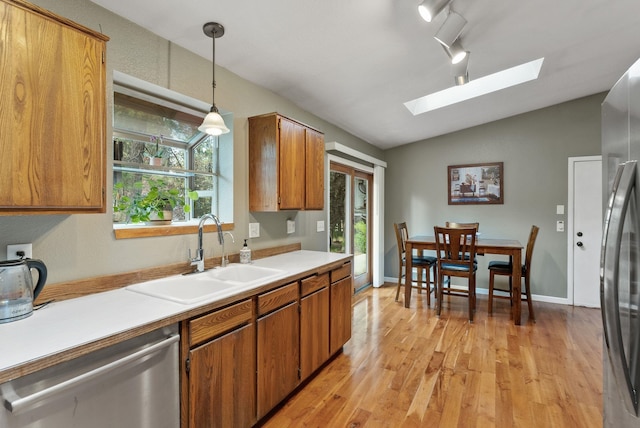15007 W Willynwood Ln, Nine Mile Falls, WA 99026 - kitchen with appliances with stainless steel finishes, a skylight, lofted ceiling, light wood finished floors, and brown cabinets