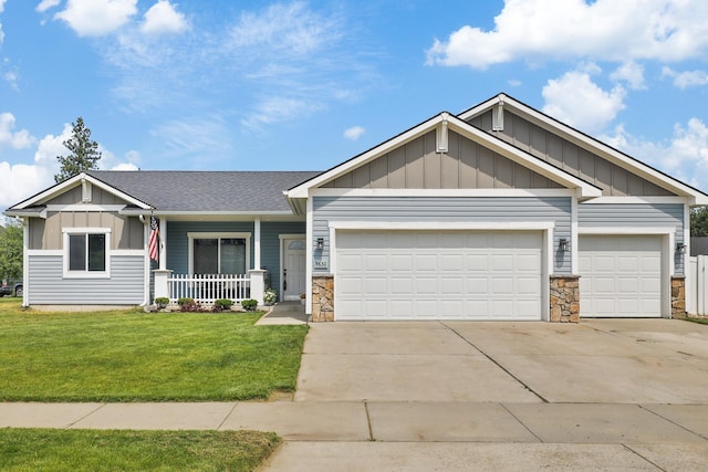 8630 W Campus Dr, Spokane, WA 99224 - craftsman-style house featuring board and batten siding, a garage, concrete driveway, a porch, and a front yard