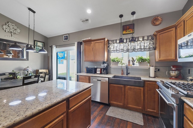 8630 W Campus Dr, Spokane, WA 99224 - kitchen with stainless steel appliances, brown cabinetry, dark wood-style flooring, and healthy amount of natural light