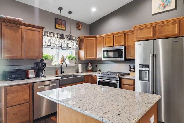 8630 W Campus Dr, Spokane, WA 99224 - kitchen with stainless steel appliances, brown cabinets, light stone countertops, pendant lighting, and a kitchen island