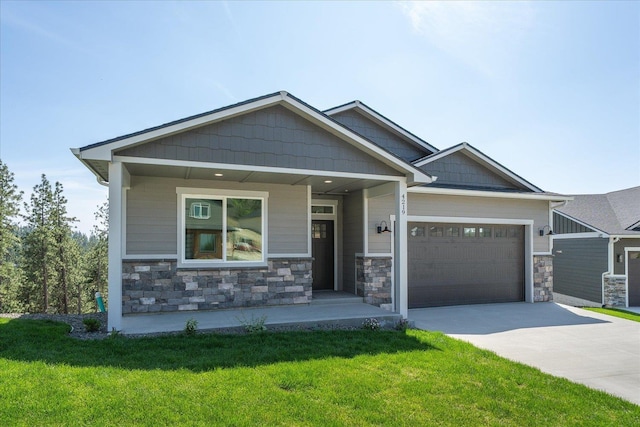 4219 W Tolliver Ct, Spokane, WA 99208 - craftsman-style home with a garage, concrete driveway, a front yard, and stone siding