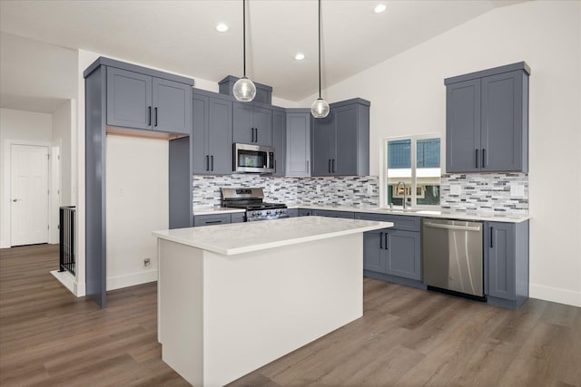 4219 W Tolliver Ct, Spokane, WA 99208 - kitchen featuring appliances with stainless steel finishes, vaulted ceiling, tasteful backsplash, dark wood-style flooring, and recessed lighting