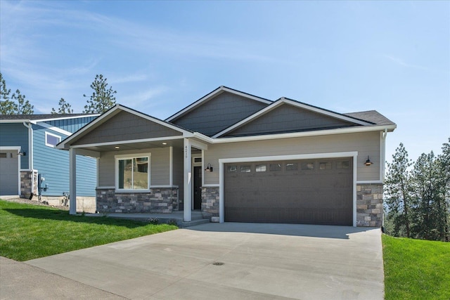 4219 W Tolliver Ct, Spokane, WA 99208 - craftsman house featuring stone siding, concrete driveway, a porch, a garage, and a front yard