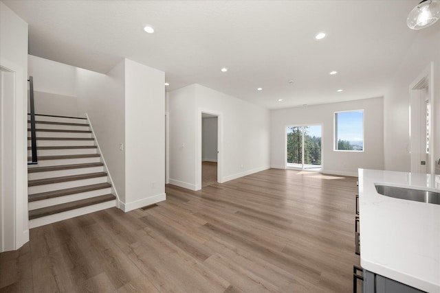 4219 W Tolliver Ct, Spokane, WA 99208 - unfurnished living room with light wood finished floors, recessed lighting, and stairway