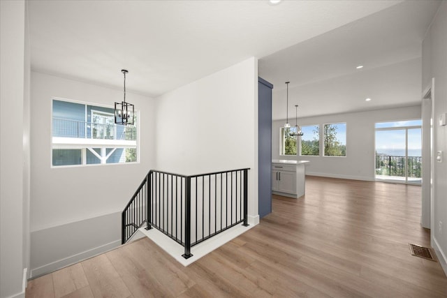 4219 W Tolliver Ct, Spokane, WA 99208 - hallway with a chandelier, an upstairs landing, light wood-style flooring, and recessed lighting