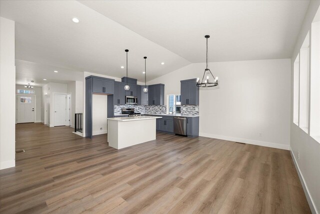 4219 W Tolliver Ct, Spokane, WA 99208 - kitchen featuring stainless steel appliances, a chandelier, vaulted ceiling, light countertops, and tasteful backsplash