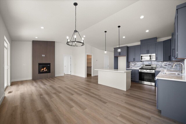 4219 W Tolliver Ct, Spokane, WA 99208 - kitchen with stainless steel appliances, light countertops, vaulted ceiling, backsplash, and open floor plan