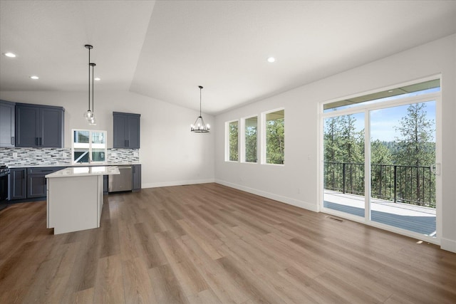 4219 W Tolliver Ct, Spokane, WA 99208 - kitchen with lofted ceiling, light countertops, stainless steel dishwasher, backsplash, and a chandelier